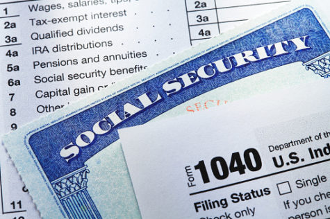 A Social Security card rests in between the pages of a 1040 tax form.